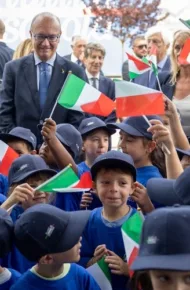il presidente Mattarella all'inaugurazione con bambini che sventolano bandierine dell'Italia